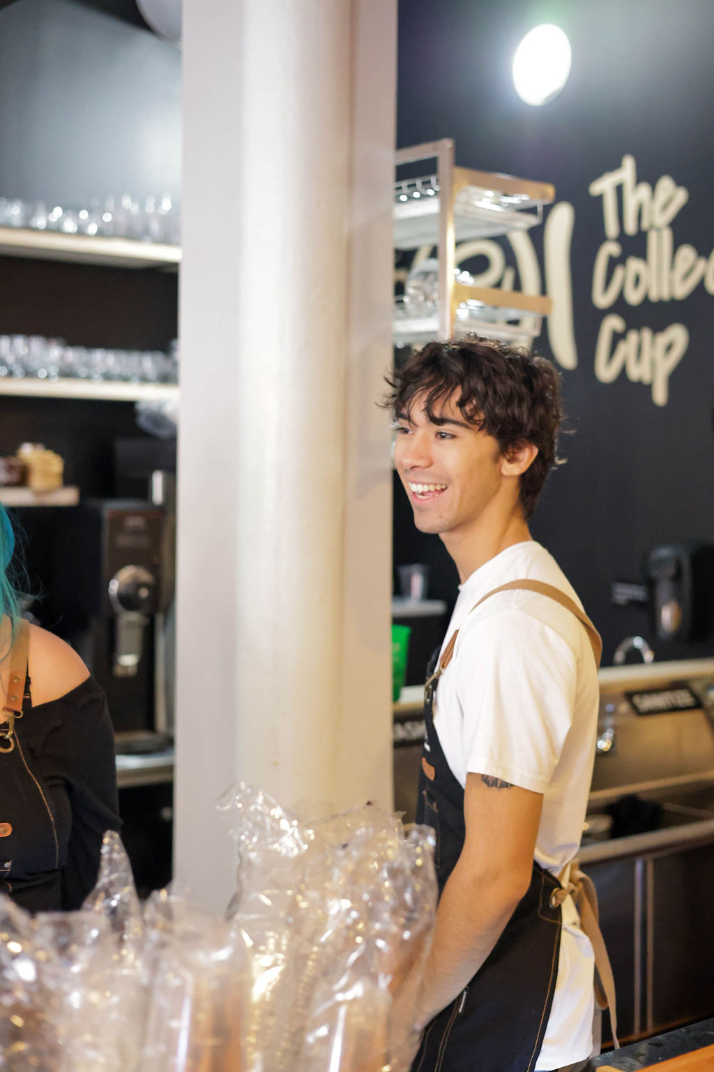 A smiling team member in an apron behind the counter